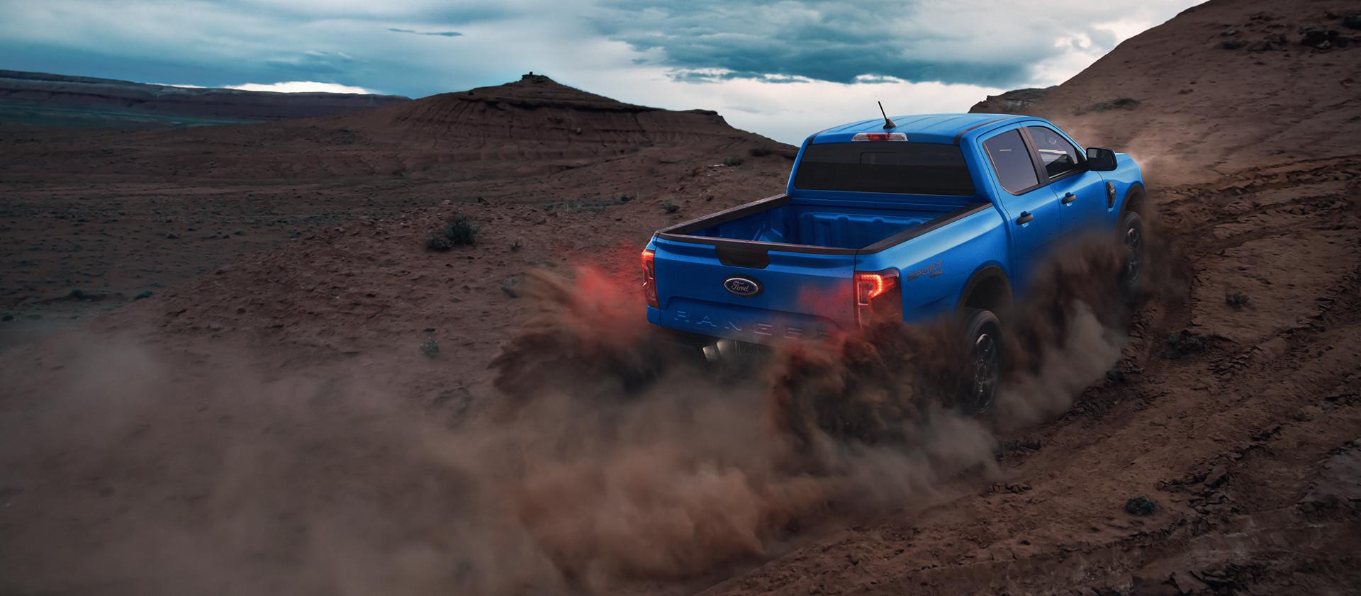 Vue arrière d'un camion Ford Ranger® 2025 étant conduit projetant de la poussière