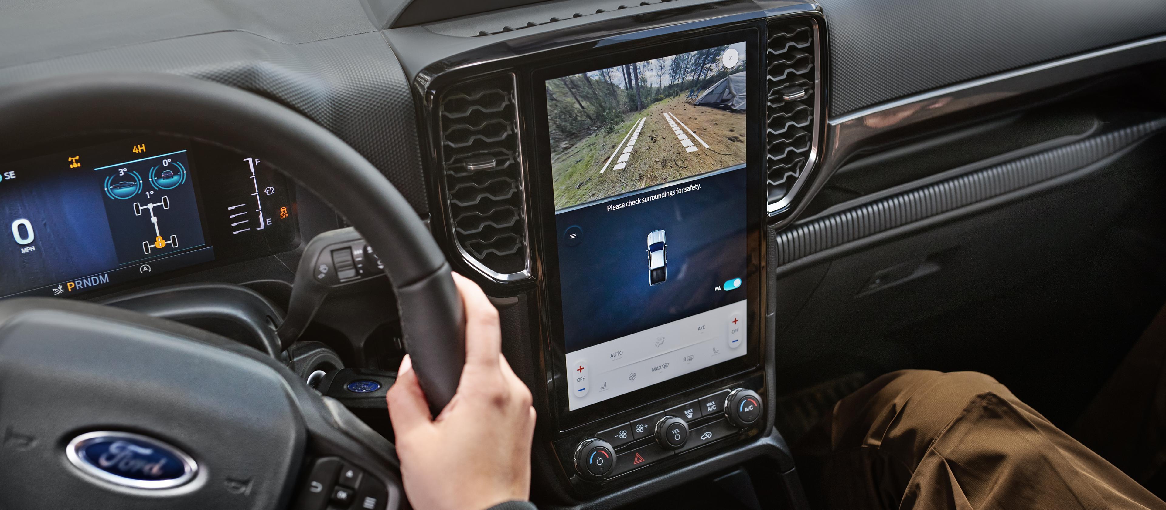 Vue intérieure du modèle Ford Ranger® XLT 2026 mettant en évidence l’écran central, l’écran du tableau de bord et le volant