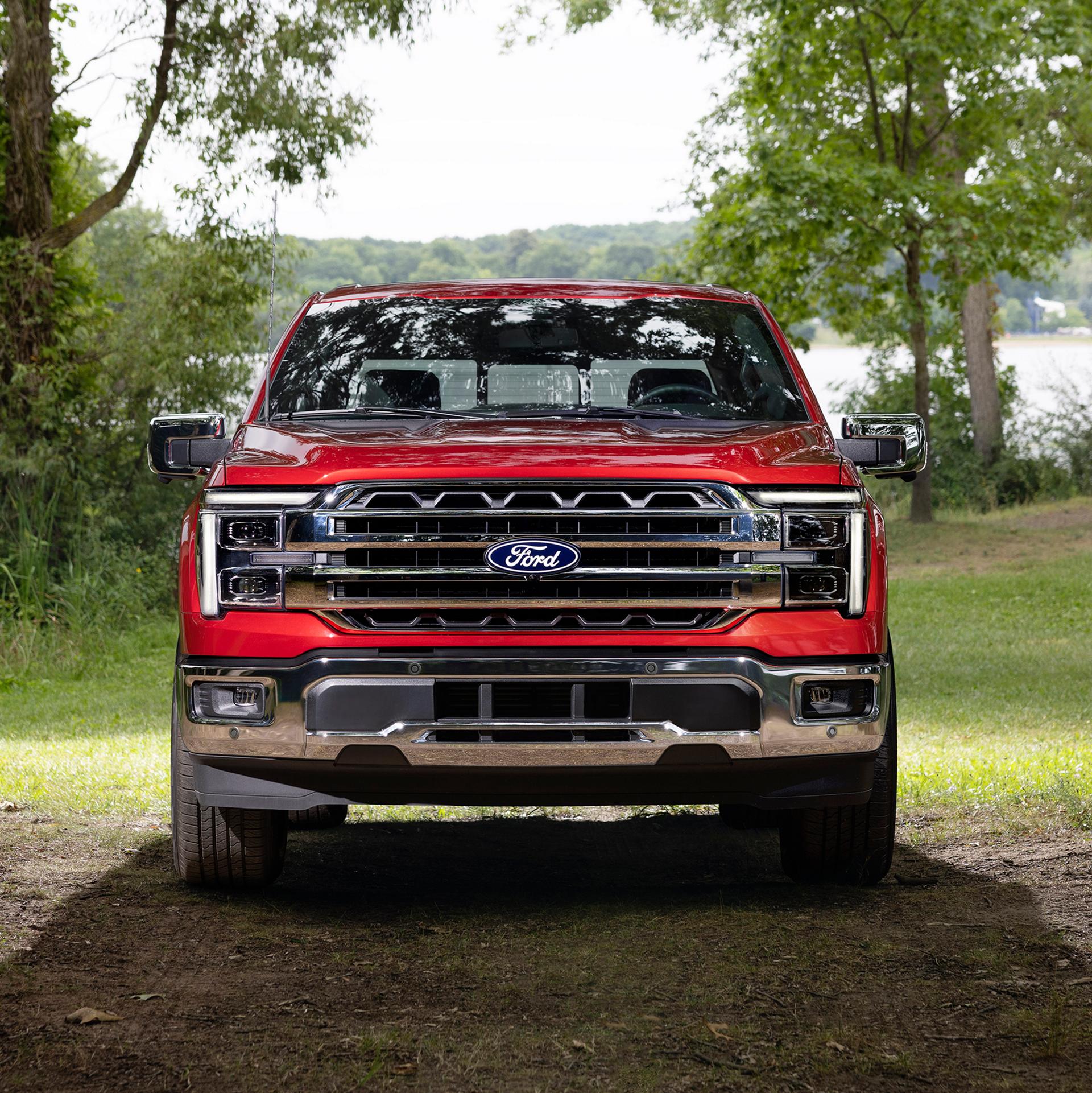 Vue avant de la calandre d’un Ford F-150® Lariat® 2027 stationné dans un environnement boisé