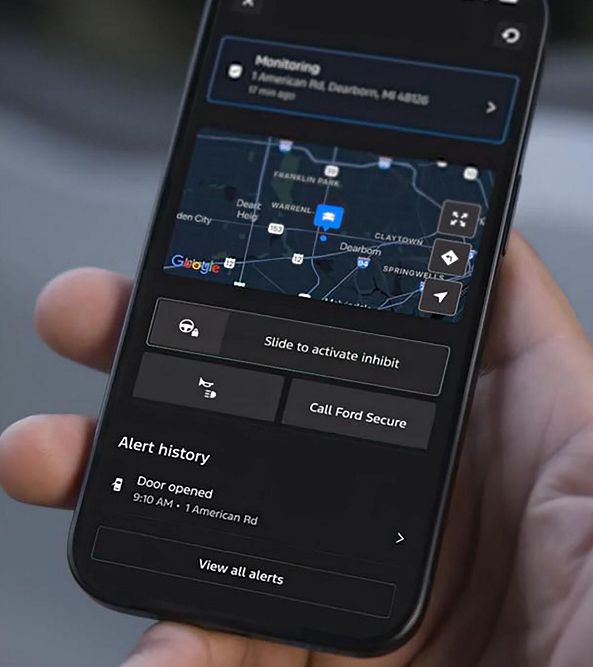 Une main tenant un téléphone intelligent affichant l’interface de l’ensemble de sécurité Ford dans l’application Ford