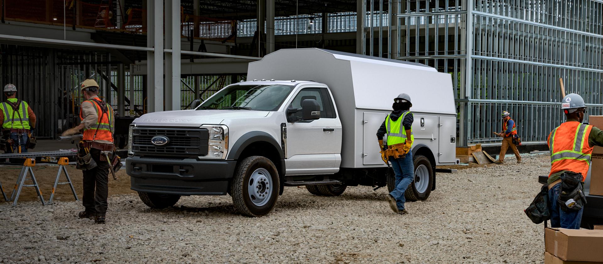 Ouvriers utilisant un Ford Super Duty® à châssis-cabine 2026 équipé d’un coffre utilitaire sur un chantier de construction