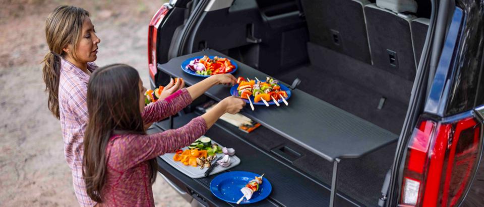 Des personnes utilisant l'organisateur de hayon de chargement dans un VUS Ford Expedition® 2025 stationné