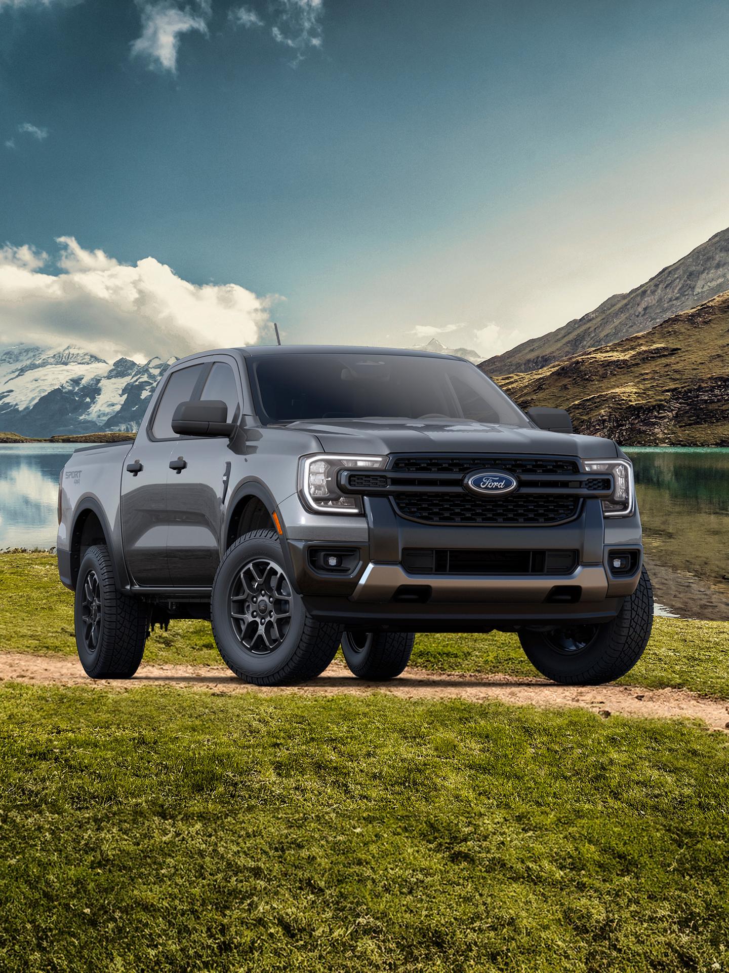 Un modèle Ford Ranger® XLT 2026 avec ensemble décor sport stationné sur une route de terre près d’un lac de montagne