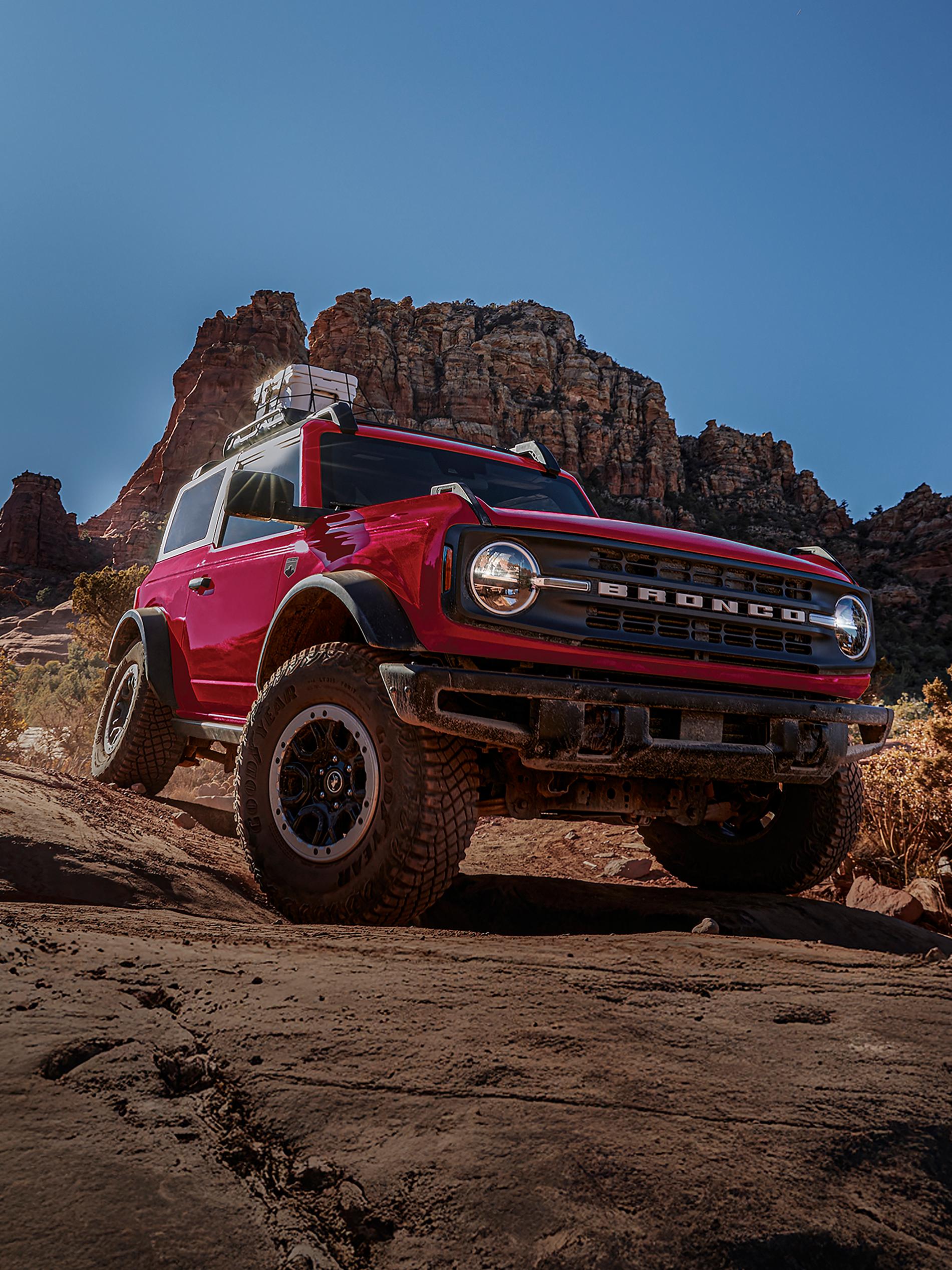 Un VUS Ford Bronco® 2026 avec l’ensemble Sasquatch® en option descendant une colline boueuse
