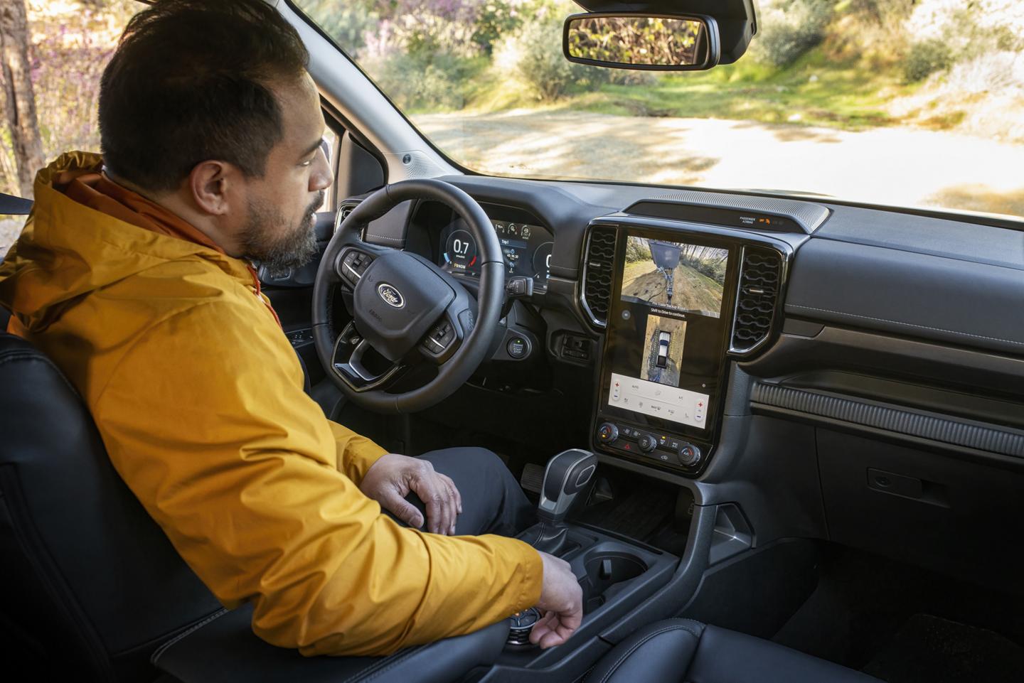 Une personne assise sur le siège du conducteur de son camion Ford Ranger® Lariat® 2026 et utilisant la fonction Pro Trailer Backup Assist™