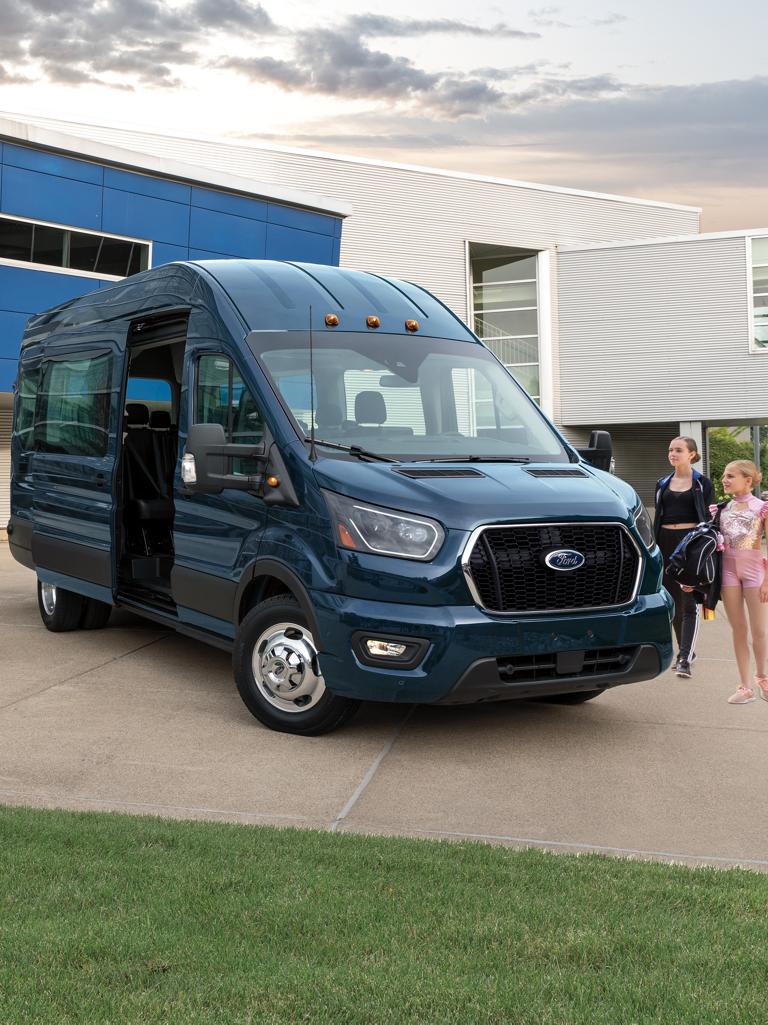 Une famille près d’une fourgonnette Ford Transit® 2026 utilisant la fonction d’assistance à la fermeture de la portière du côté passager