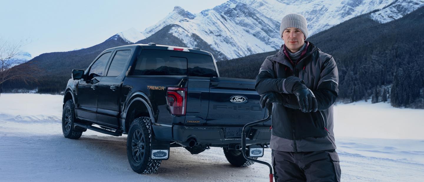 Carey Price se tient devant un F-150 Tremor sur une route de montagne enneigée.