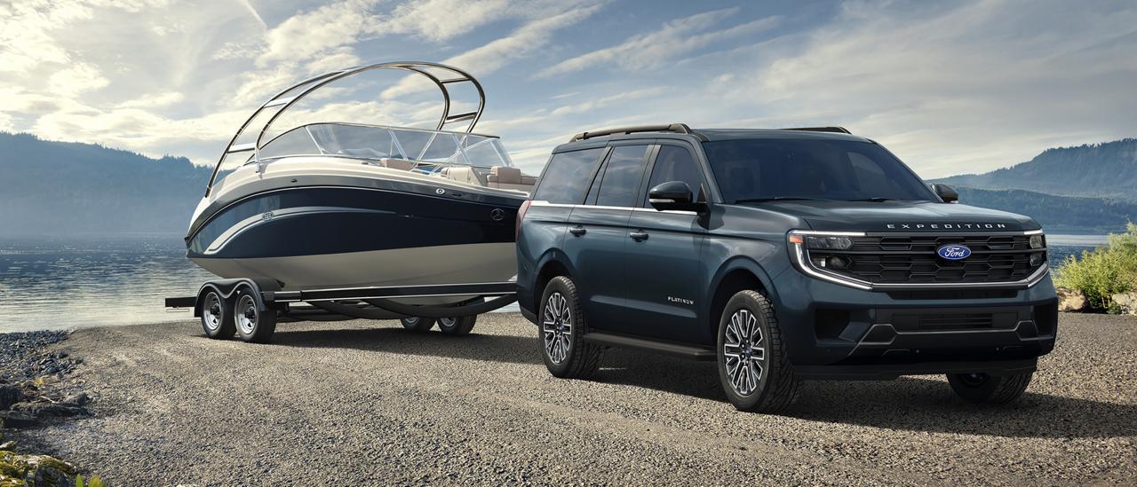 Modèle Ford Expedition® 2027 avec un conducteur tirant un bateau sur une remorque