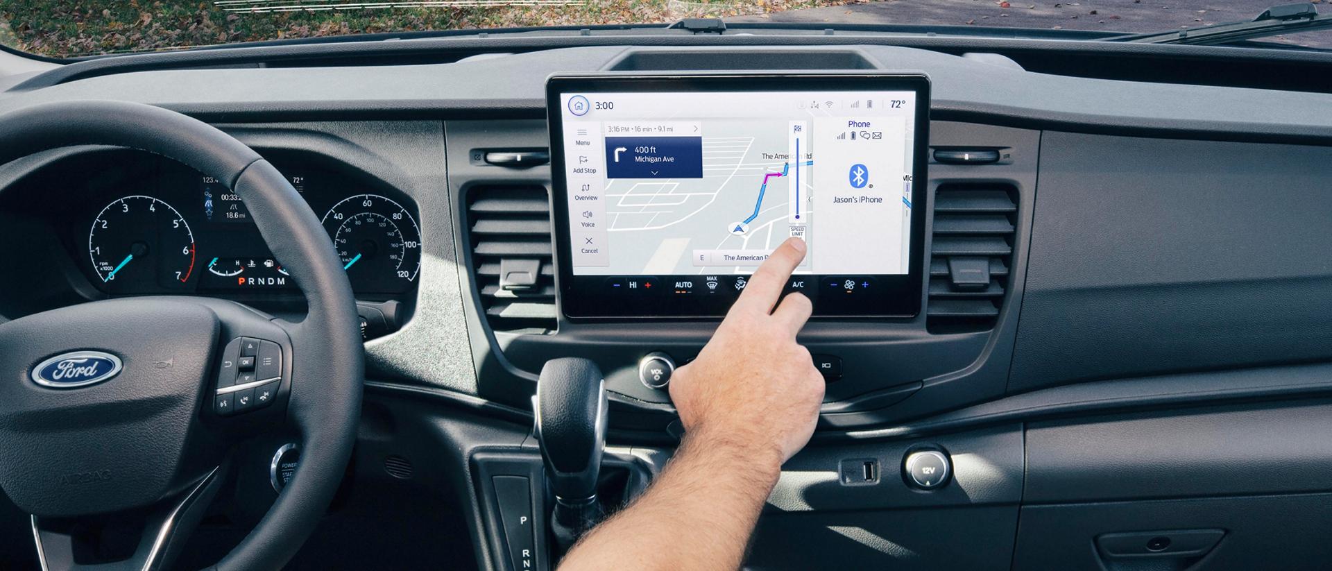 Intérieur d’une fourgonnette Ford Transit® 2025 avec une personne interagissant avec l’écran tactile