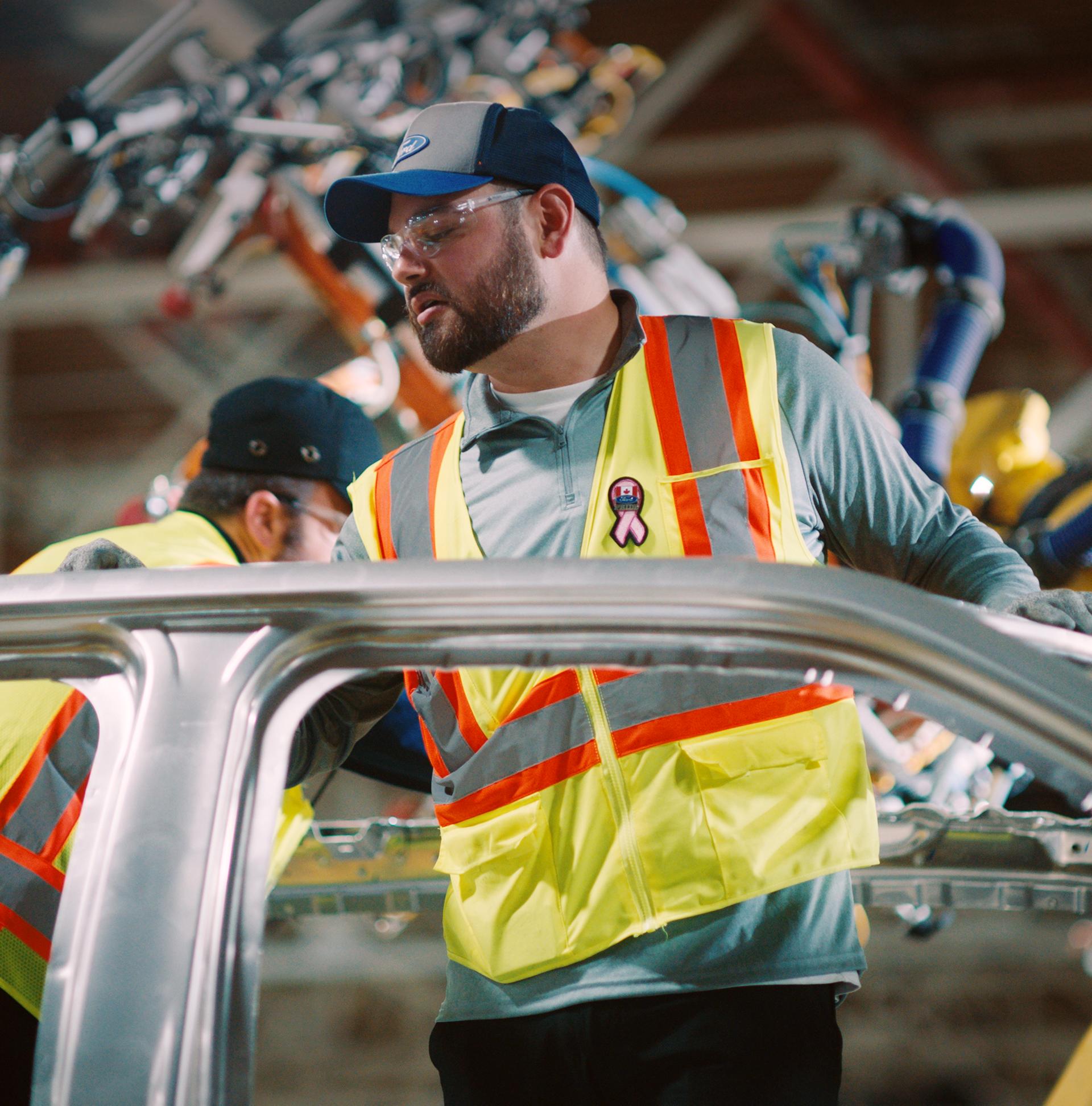 Un employé de Ford assemble un véhicule.