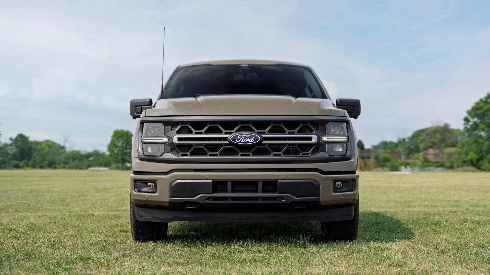 Vue avant de la calandre d’un modèle Ford F-150® XLT 2027 doté de l’ensemble Carhartt®, stationné dans un champ