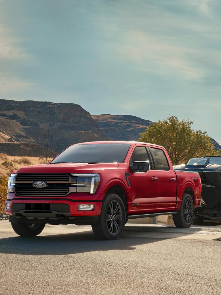 Ford F-150® STX® FX4 2025 rouge rubis métallisé tirant un bateau hors de l'eau