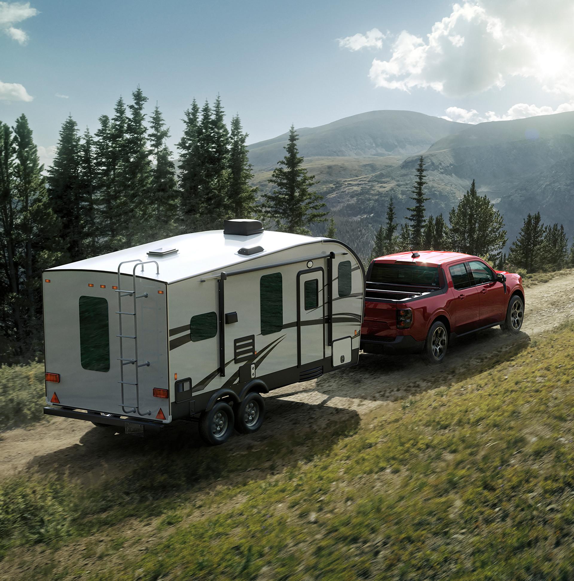 Modèle Ford Maverick® Lariat® 2026 en vernis teinté rouge rubis métallisé (en option) tirant une caravane sur le col sinueux d’une montagne.