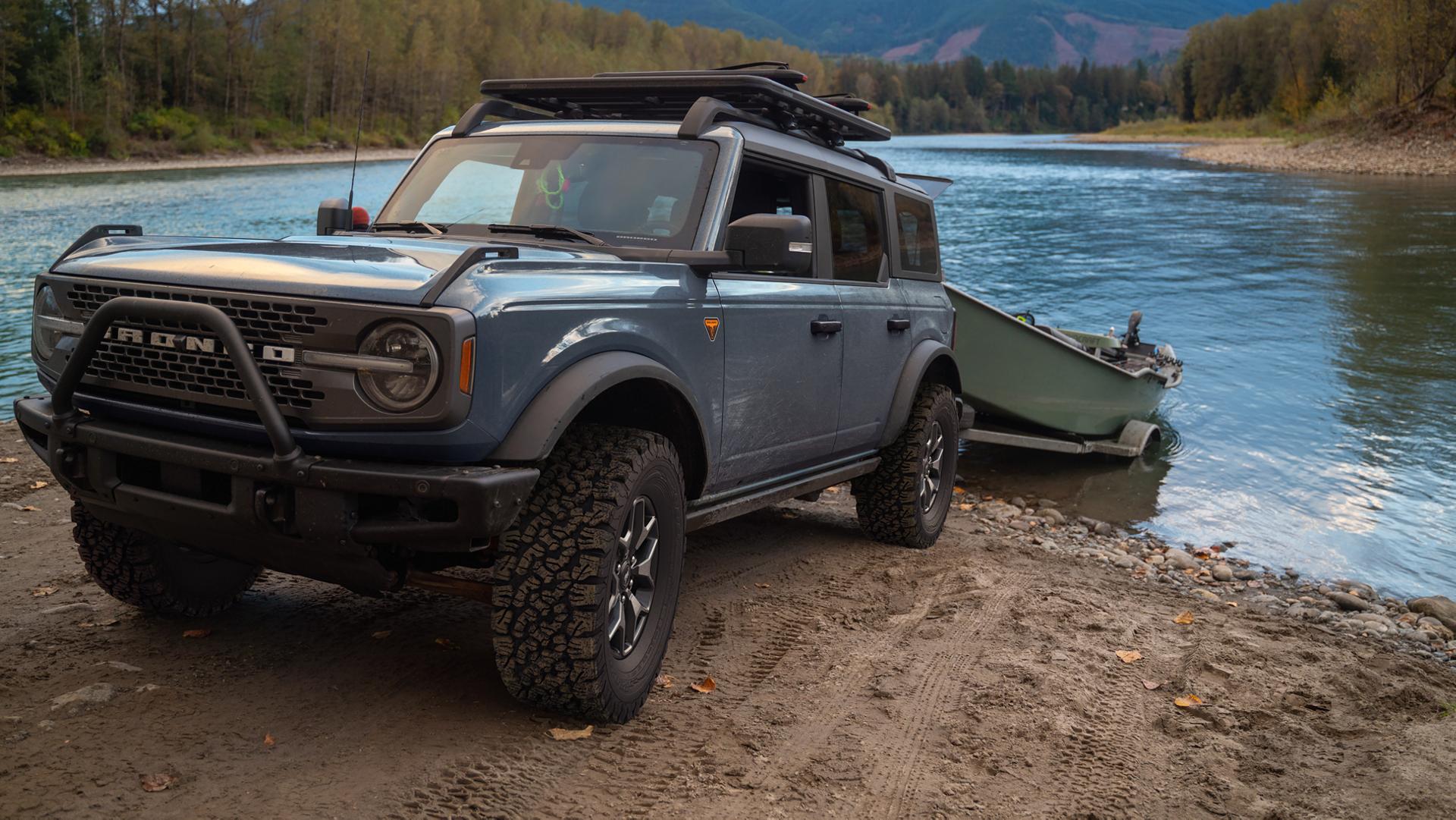 Un VUS Ford Bronco® 2025 reculant une remorque de bateau dans un lac de montagne