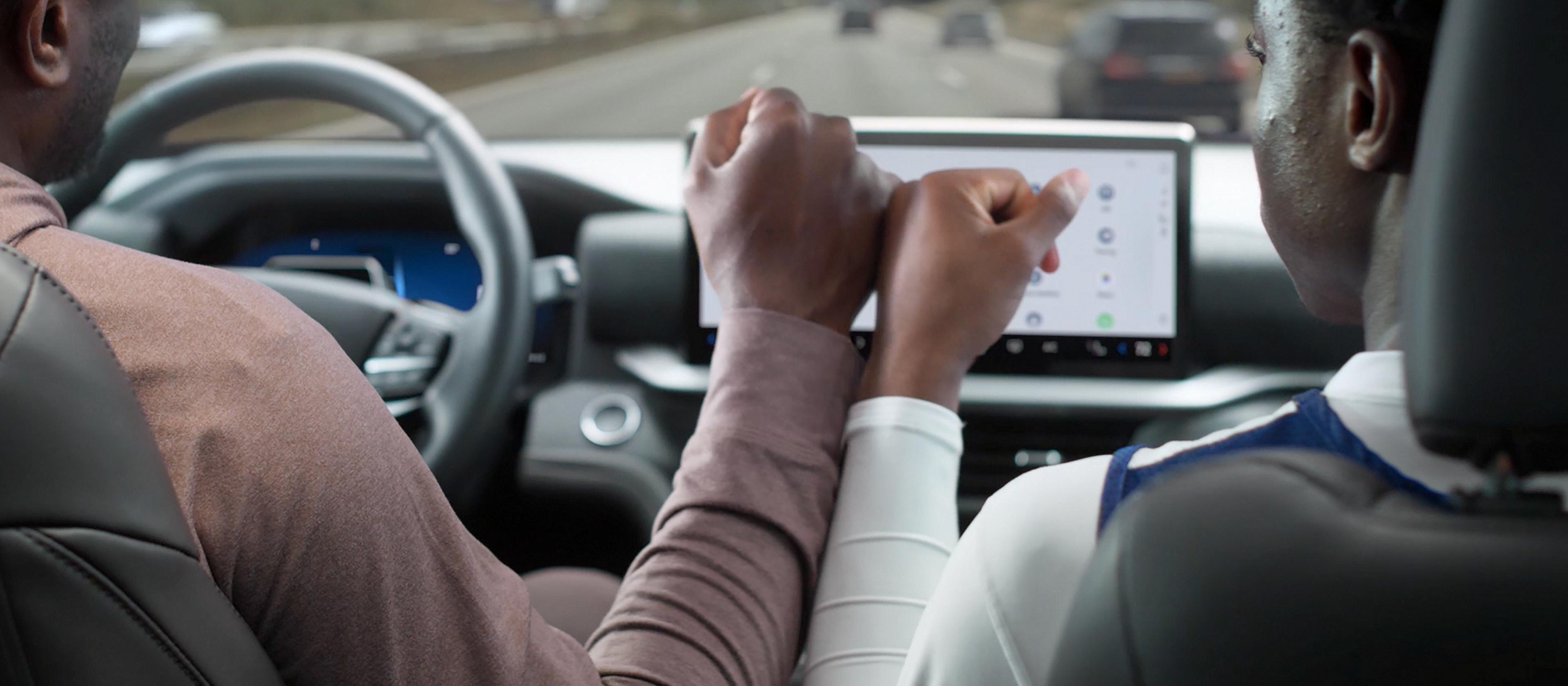 Un conducteur et un passager se touchant les mains dans un VUS Ford Explorer® 2026 alors que BlueCruise est actif