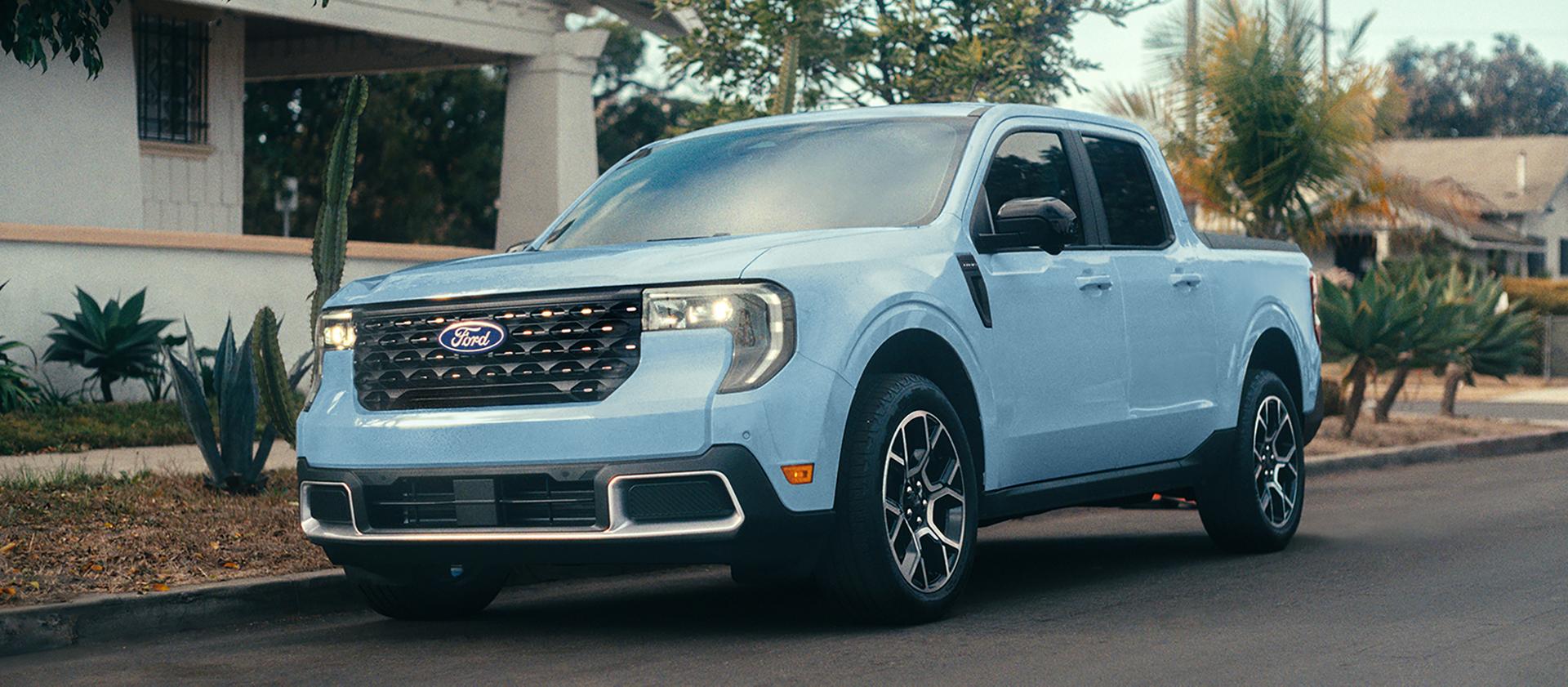 Camionnette Ford Maverick® 2026 bleu clair stationnée dans la rue devant une maison
