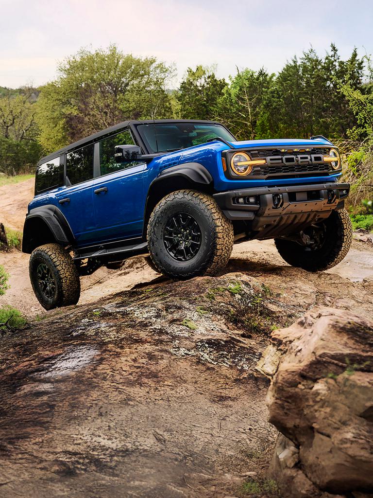 Un VUS Ford Bronco® Raptor® 2026 équipé d’un ensemble décor noir en option, roulant sur une formation rocheuse.