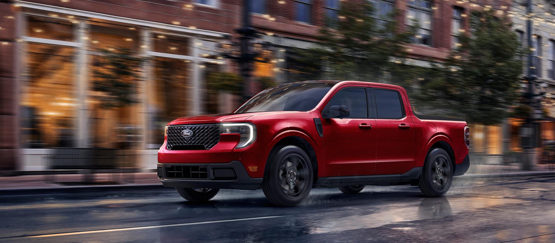 Une camionnette Ford Maverick® 2026 avec ensemble décor noir circulant dans une rue de la ville le soir