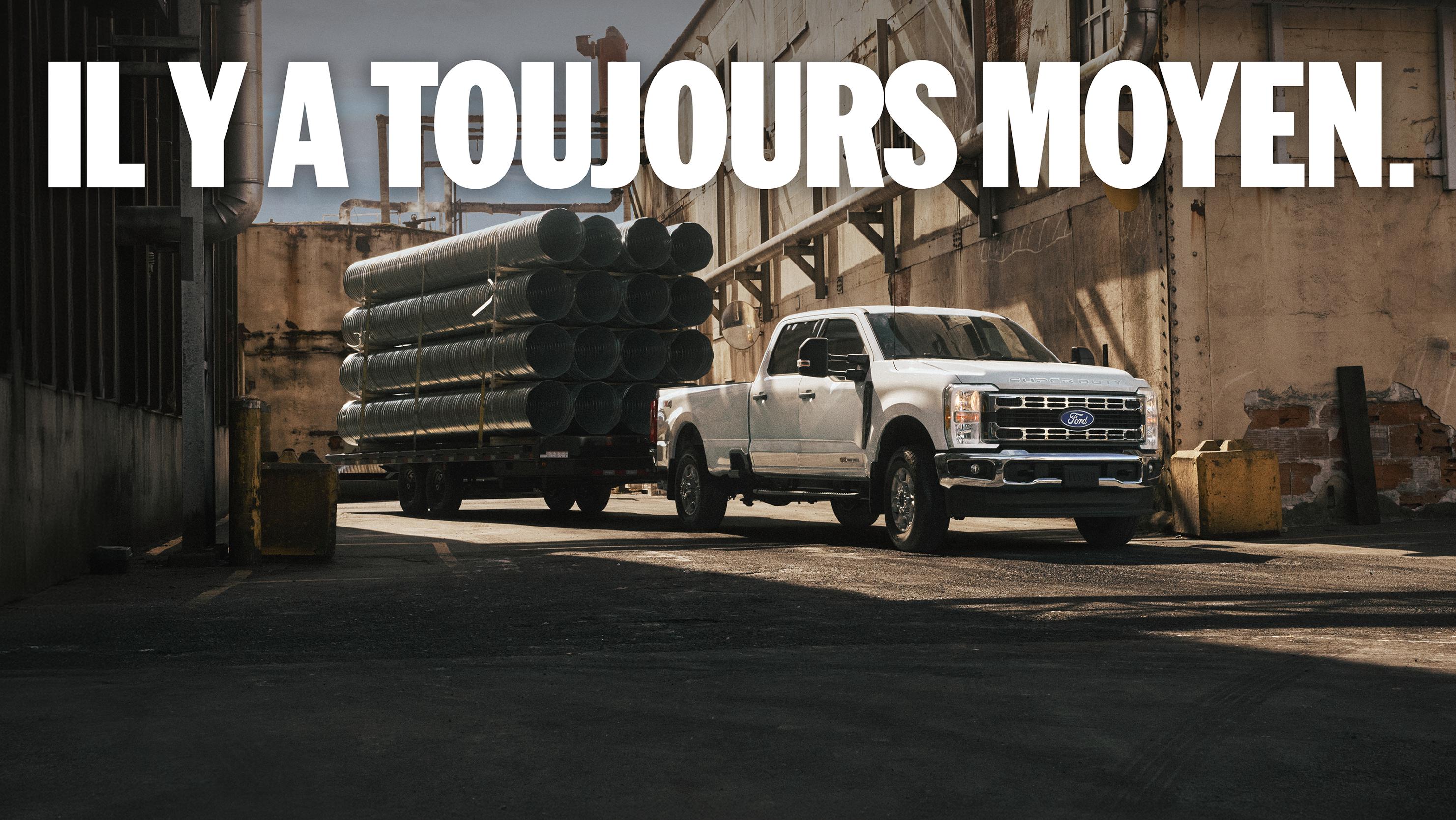 Un Super Duty stationné sur un chantier avec une remorque attelée chargée de tubes d’acier. Le texte superposé indique : « Il y a toujours un moyen ».