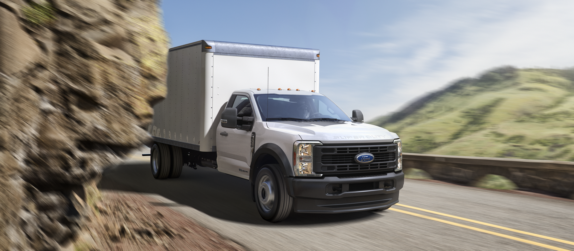 Un Ford Super Duty® à châssis-cabine 2026 avec caisson circulant dans une courbe de montagne serrée