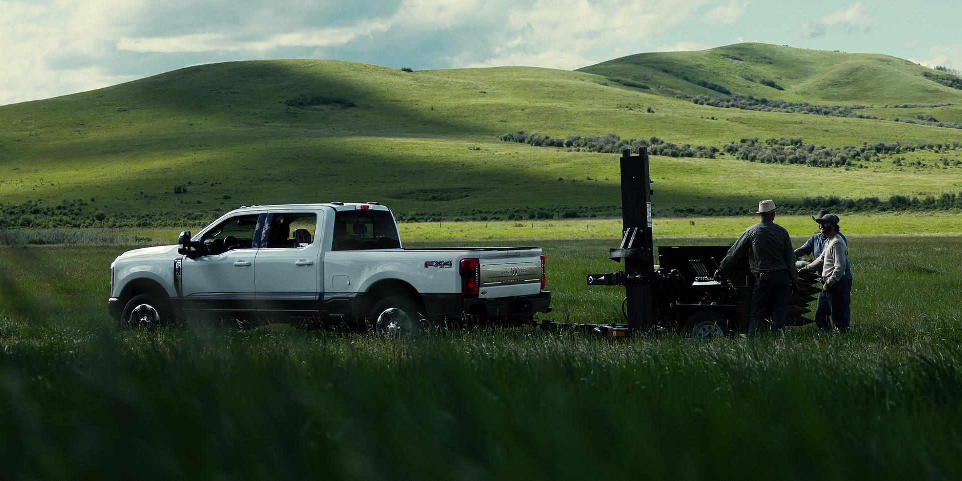 Modèle Ford Super Duty® F-350® Platinum™ 2027 remorquant un bateau à moteur sur une route pavée.