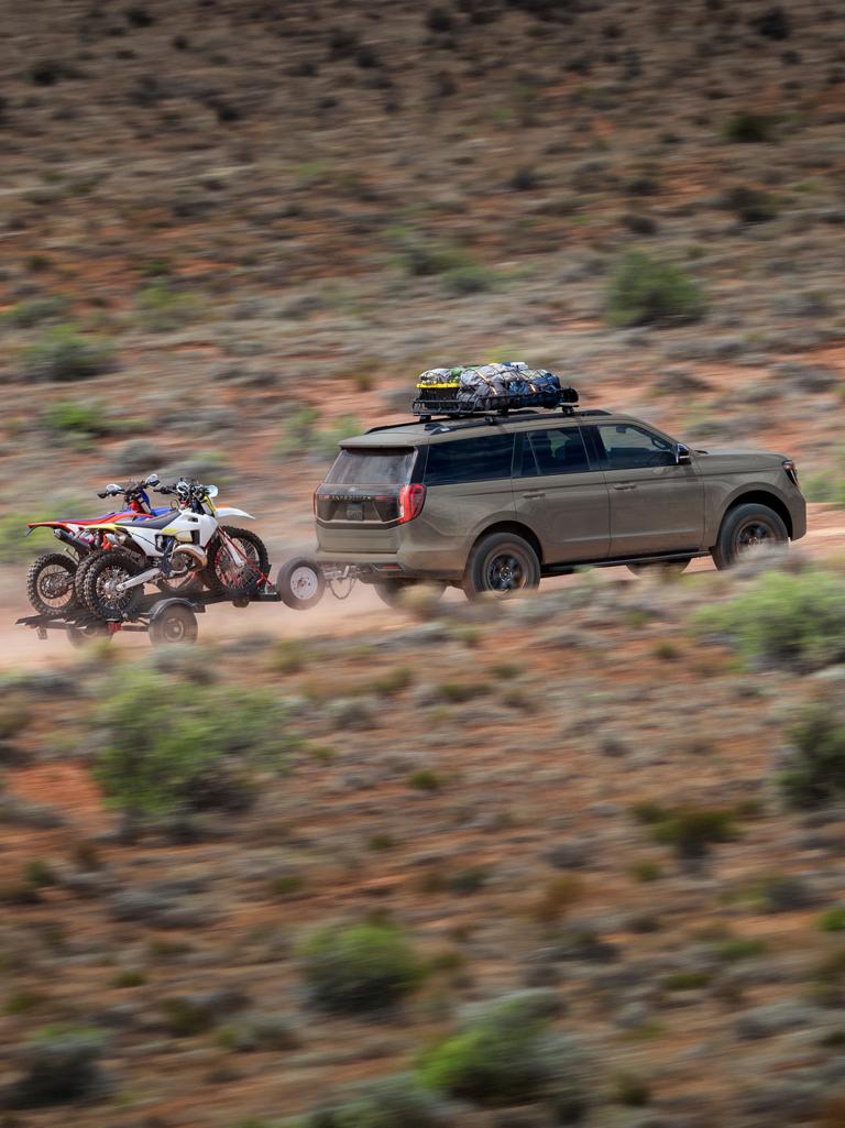 Le VUS Ford Expedition® Tremor® 2026 remorquant une remorque de moto tout-terrain dans le désert