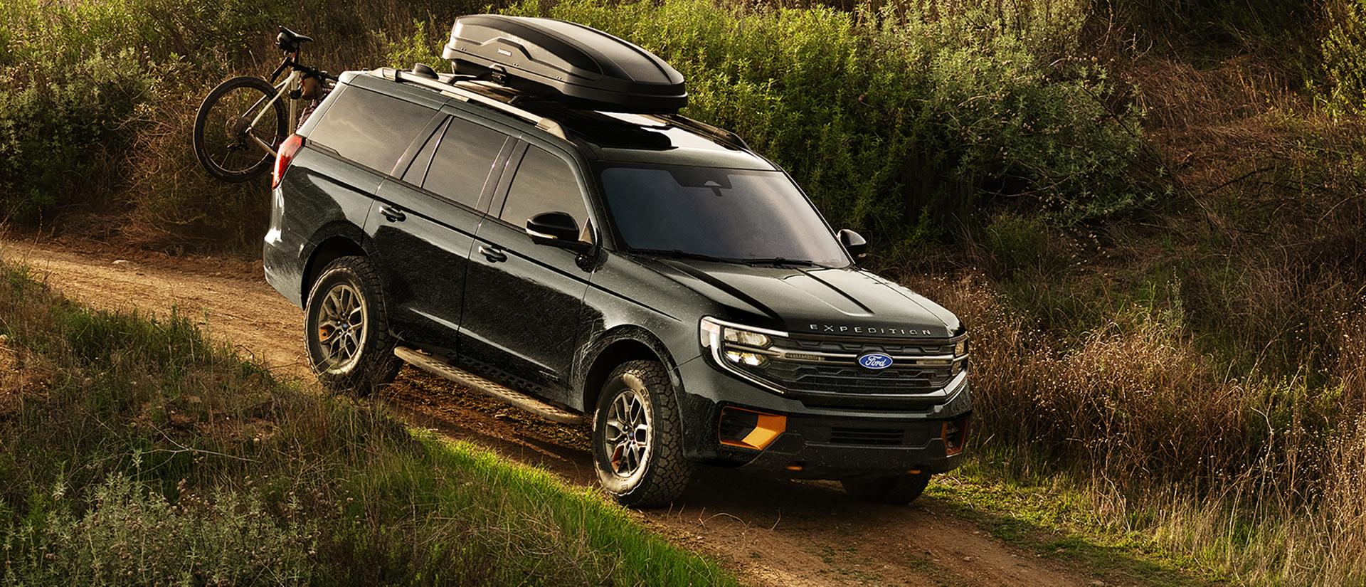VUS Ford Expedition® Tremor® 2027 avec équipement en option et accessoires Ford offerts en option, présenté roulant sur un chemin de terre