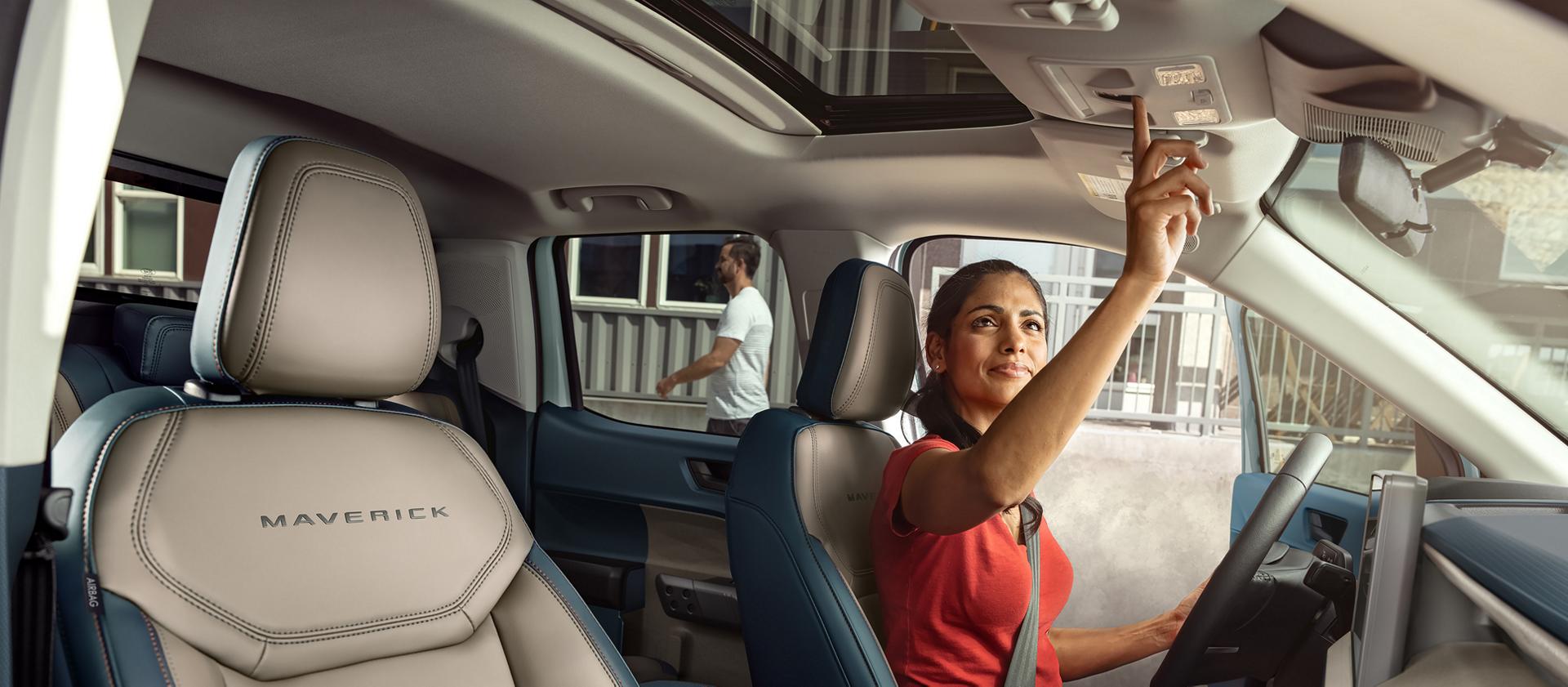 Vue intérieure de l’espace passager avant montrant le volant, l’écran central et les commandes de la console centrale.