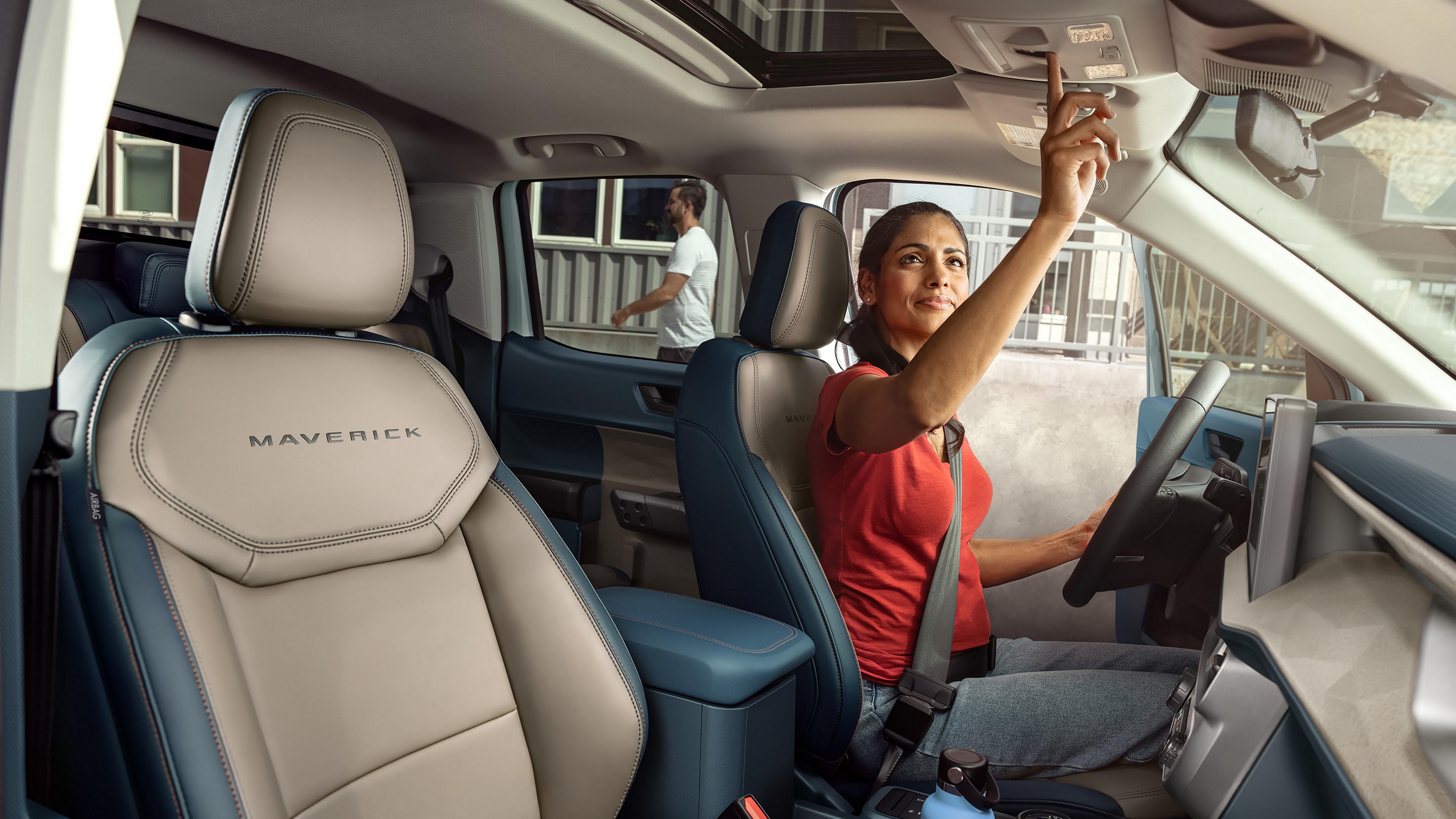 Femme utilisant les commandes du toit ouvrant à bord du Ford Maverick® Lariat® 2026