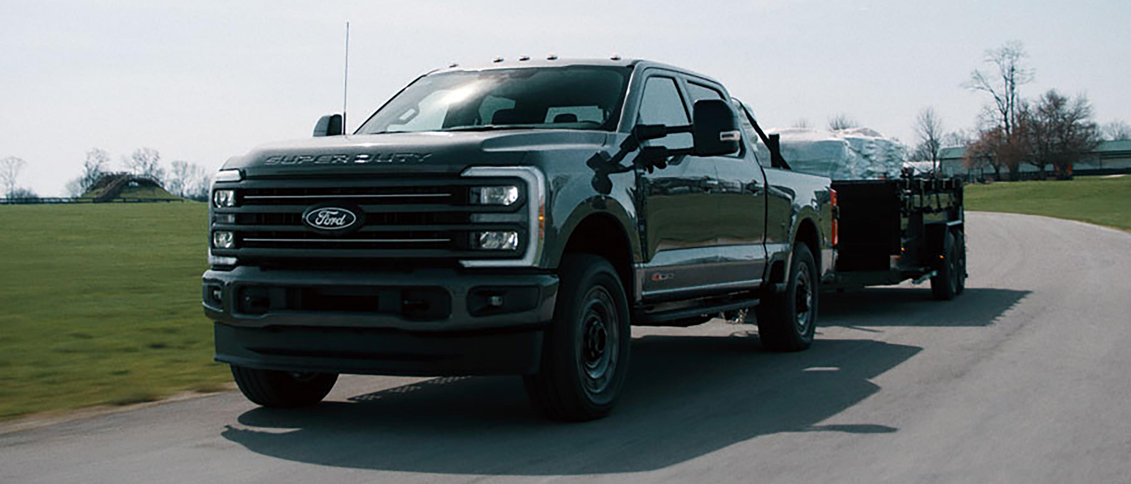 Ford Super Duty® F-350® XLT 2027 équipé de l'ensemble Super Duty Carhartt® tractant une remorque à plateau