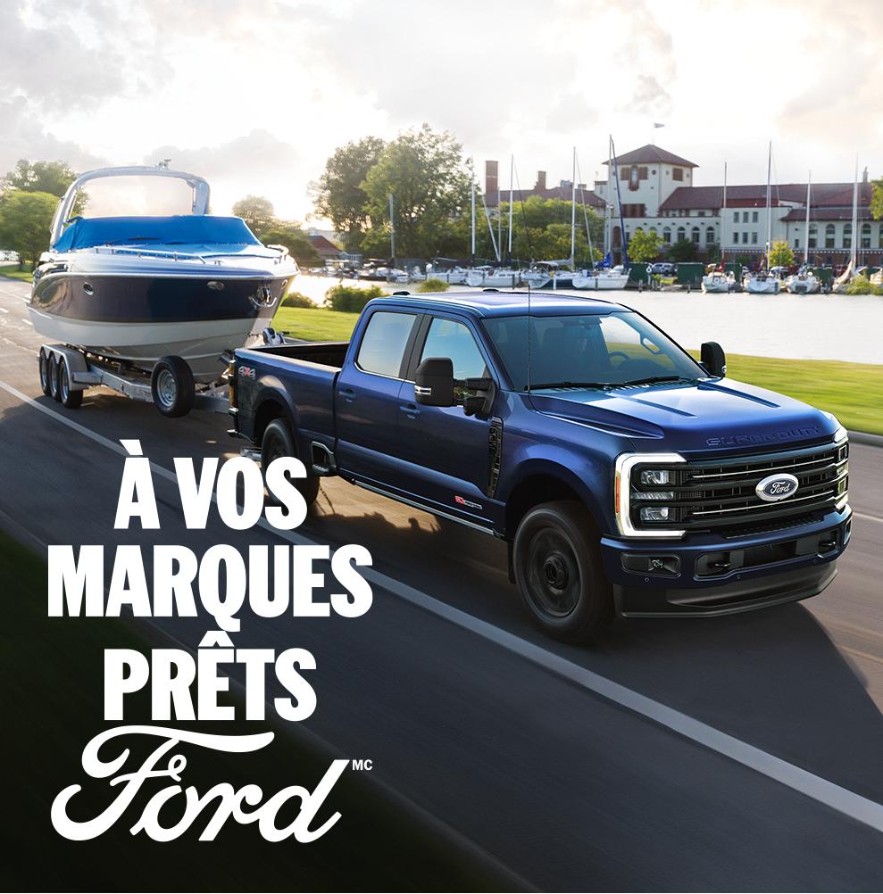 Vue de trois quarts avant d'un Ford Super Duty bleu qui remorque un bateau. Le texte blanc « À vos marques. Prêts.Ford » apparaît dans le coin inférieur droit.  