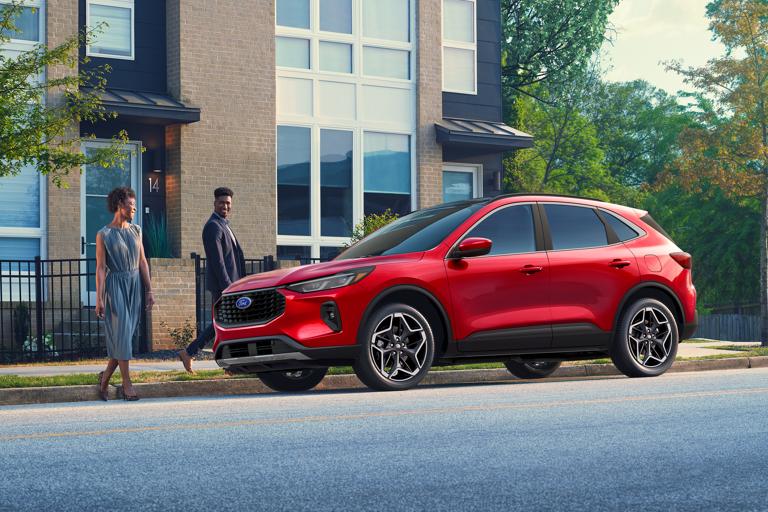 Couple marchant vers un VUS Ford Escape® 2026 de couleur rouge rapide