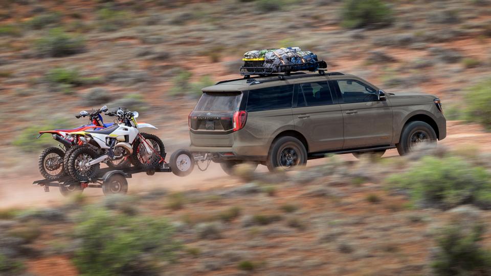 Le VUS Ford Expedition® Tremor® 2026 remorquant une remorque de moto tout-terrain dans le désert