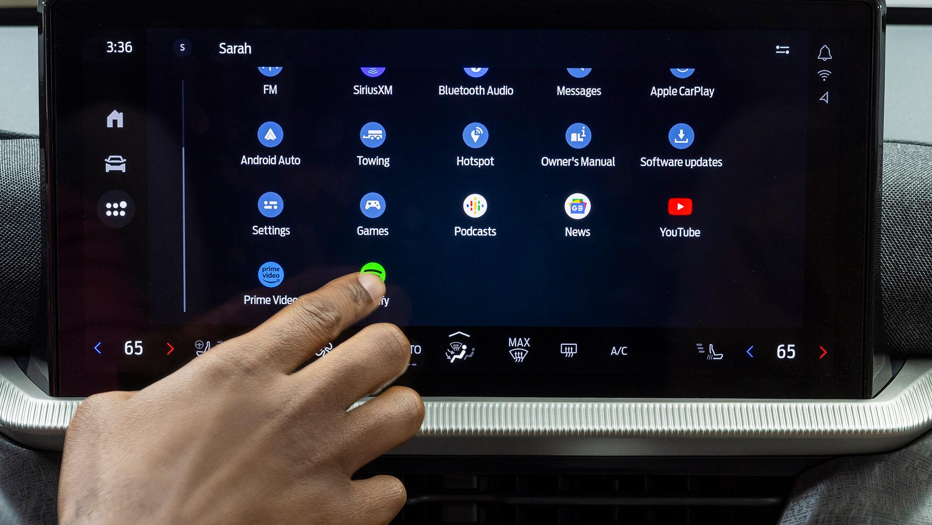 Une main du conducteur tendue pour toucher une icône sur l’écran central d’un VUS Ford Explorer® 2026