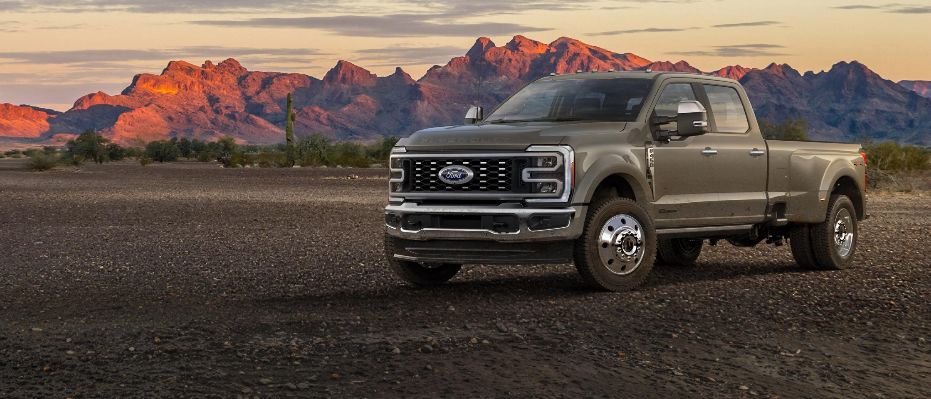 Camion Ford Super Duty® F-450® King Ranch® 2026 stationné sur du gravier avec des montagnes en arrière-plan