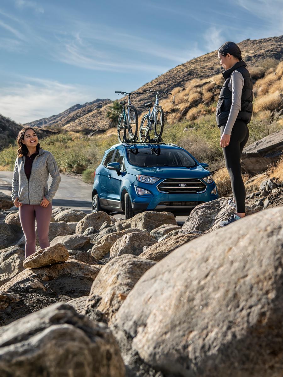 Deux jeunes femmes se tiennent dans un paysage rocheux près d'un VUS Ford.