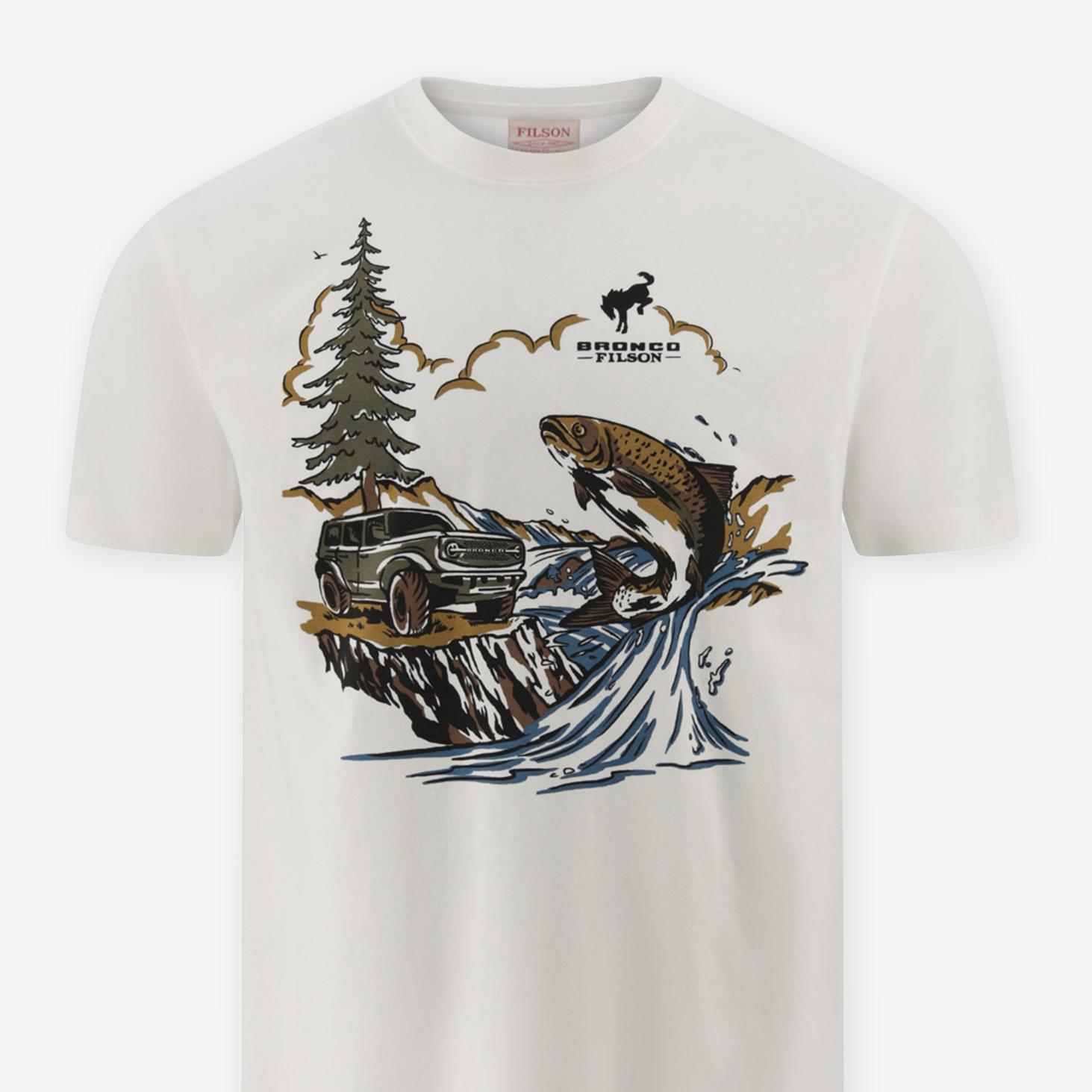 Un t-shirt couleur crème orné d'une illustration représentant une scène forestière avec un saumon bondissant, un VUS et le logo Bronco® Filson