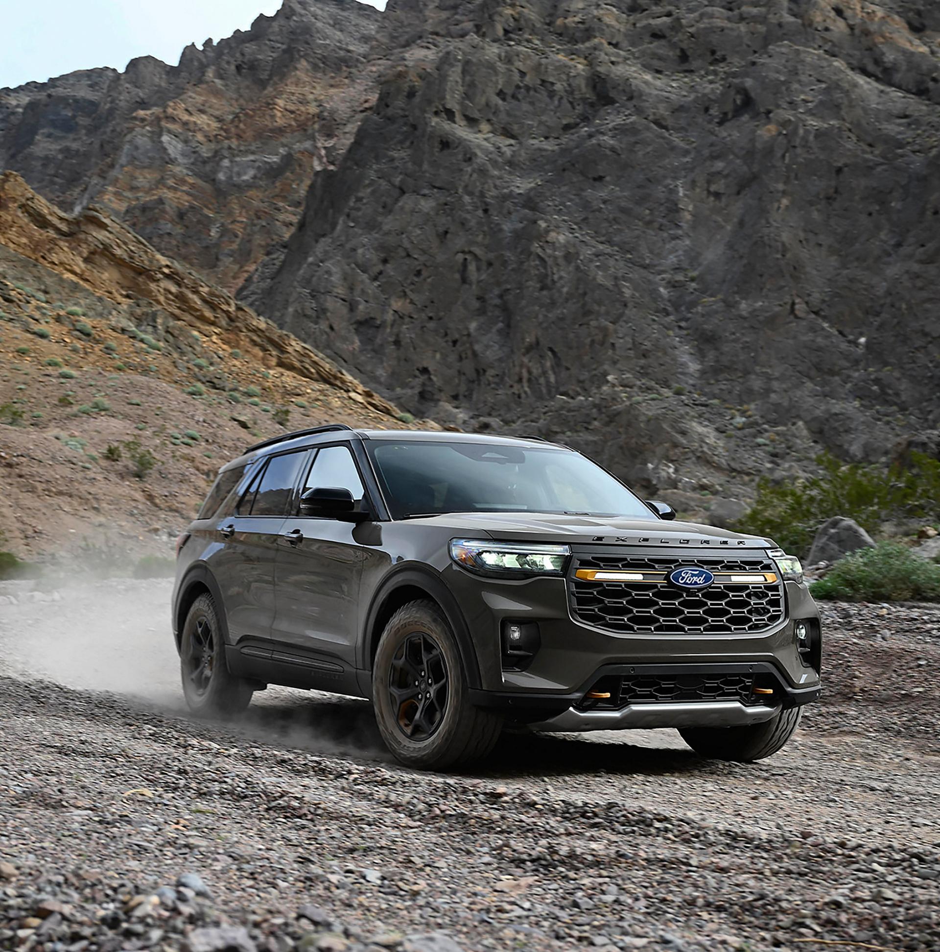 Un Ford Explorer® Tremor® 2027 soulevant de la poussière sur un chemin de gravier dans les montagnes