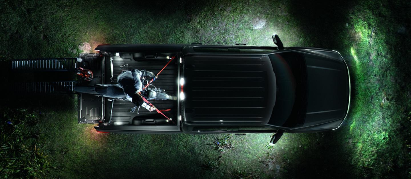 Vue aérienne d’un camion Ford F-150® Lightning® 2025 avec l’éclairage de zone à DEL qui éclaire la zone alentour