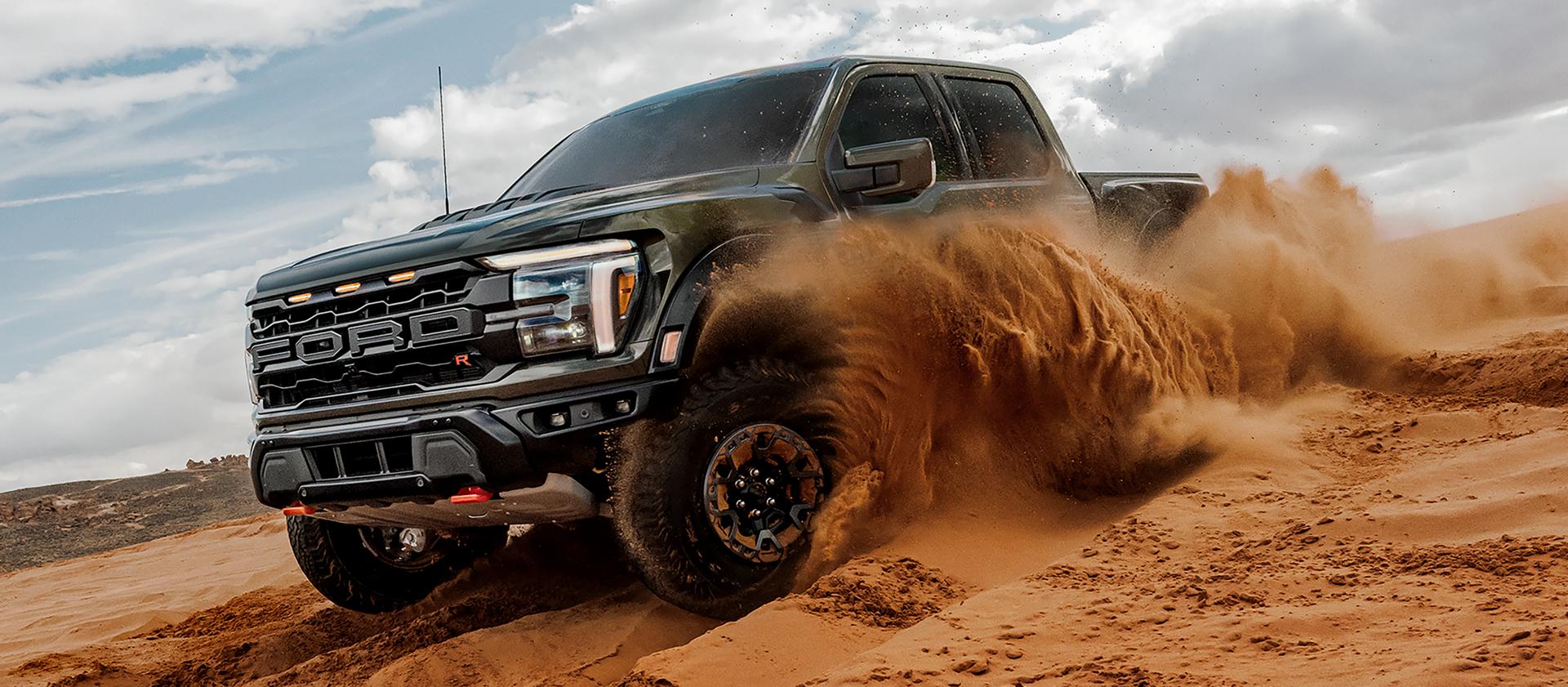 Un véhicule Ford F-150® Raptor® 2026 circule dans le désert en projetant des nuages ​​de sable