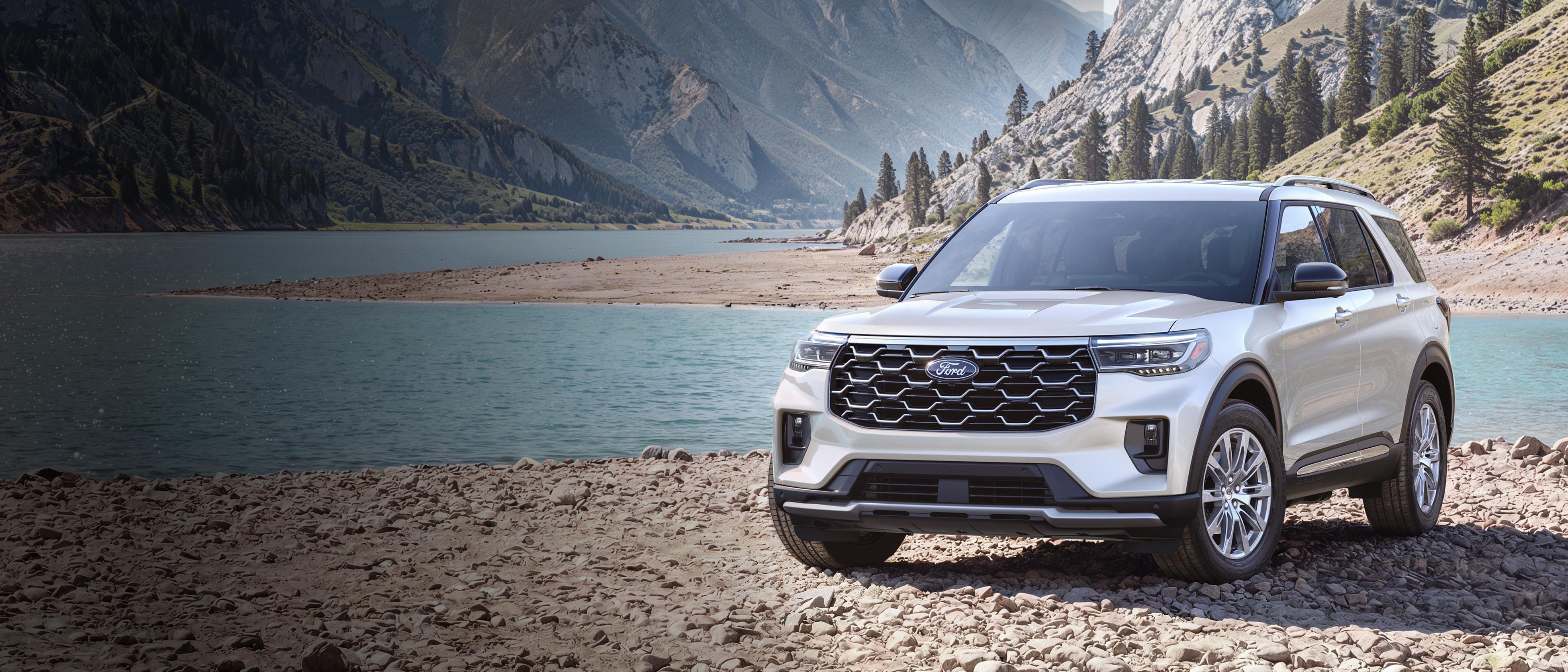 Un modèle Ford Explorer® Platinum™ 2027 stationné sur une étendue rocheuse, près d’un lac de montagne